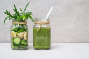 Photo of two mason jars, one with cucumber and banana slices and one with a green smoothie from "10 Green Smoothies To Beat Back Colds And Flu" by Green Smoothie Girl