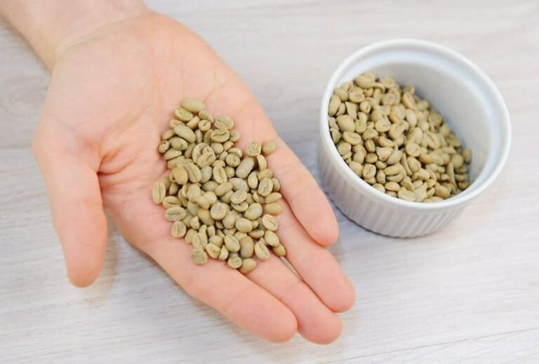 Photo of person's hand holding unroasted coffee beans in hand from "Coffee Enemas: Crazy effective, or Just Crazy?" blog post from Green Smoothie Girl