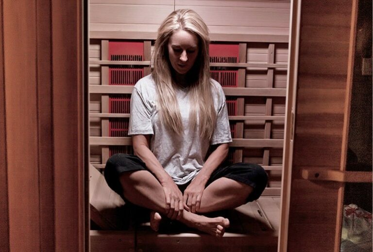 Robyn sitting in a yoga pose in her sauna from Green Smoothie Girl's "19 Benefits of Infrared Saunas"