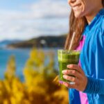 a woman outside holds a green smoothie from Green Smoothie Girl's "10 Fall Smoothies"