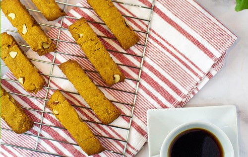 slices of biscotti on a tray over a red and white cloth from Green Smoothie Girl's "Chocolate Pumpkin High-Protein Biscotti Recipe"