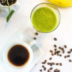 A cup of coffee next to a glass of green smoothie with coffee beans scattered around from Green Smoothie Girl's "Wake Up! Green Smoothie"