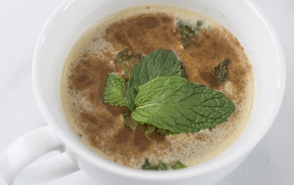 a steaming mug of coffee with mint leaves in it from Green Smoothie Girl's "Healthy High-Protein Peppermint Mocha"