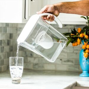 A man pouring water from a Clearly Filtered pitcher into a glass