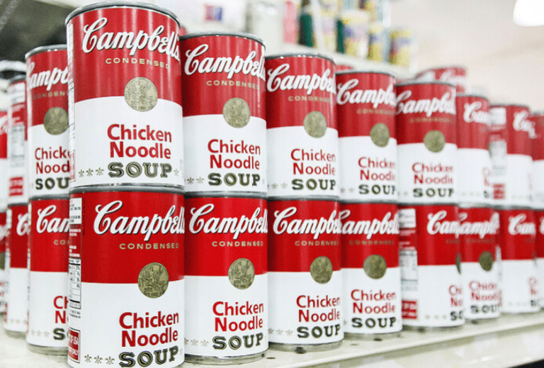cans of Campbell's soup stacked on grocery shelves