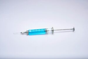 Minimal syringe and vial representing peptide injections and research chemicals